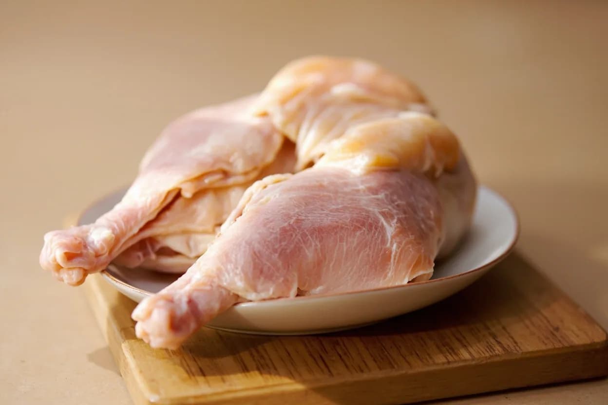 Spatchcock / Butterfly (Poultry) in its raw whole-cut form on a butcher's board — Spatchcocking (also called butterflying) is the technique of removing the entire backbone of a whole bird using kitchen shears or a heavy knife, then pressing the carcass flat by cracking or removing… Identifying traits: Reduces roast or grill time by 30–40% compared to a trussed whole bird, Entire skin surface faces heat simultaneously — maximum crispness, Thigh and breast temperatures converge during cooking, reducing overcooking risk.